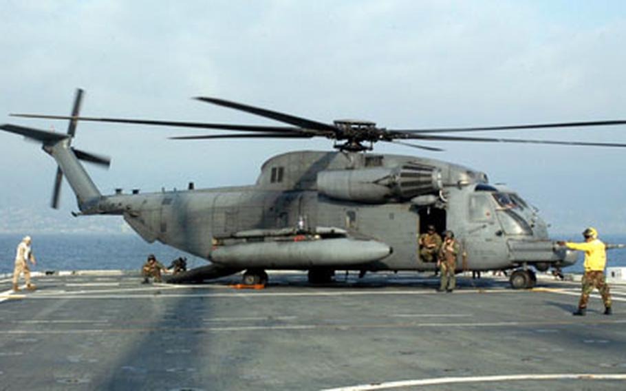 With the coastline of Beirut, Lebanon, in the background, an MH-54 Pave Low helicopter sits on the back of a U.S. Navy ship being used to help evacuate American citizens from the war-torn country in this file photo.