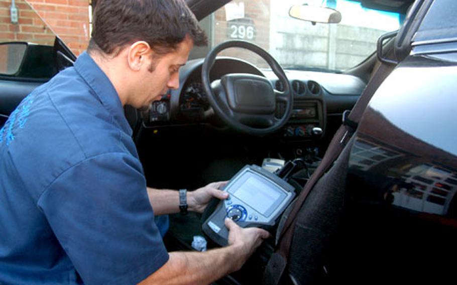Jason Butnor, a mechanic at RAF Mildenhall’s Auto Hobby Shop, uses a Genisys diagnostic machine on a Pontiac Firebird on Tuesday.