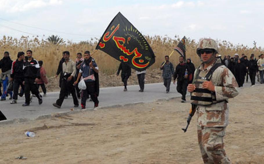 An Iraqi soldier stands guard Tuesday during a Shiite pilgrimage through Lutafiyah, south of Baghdad.