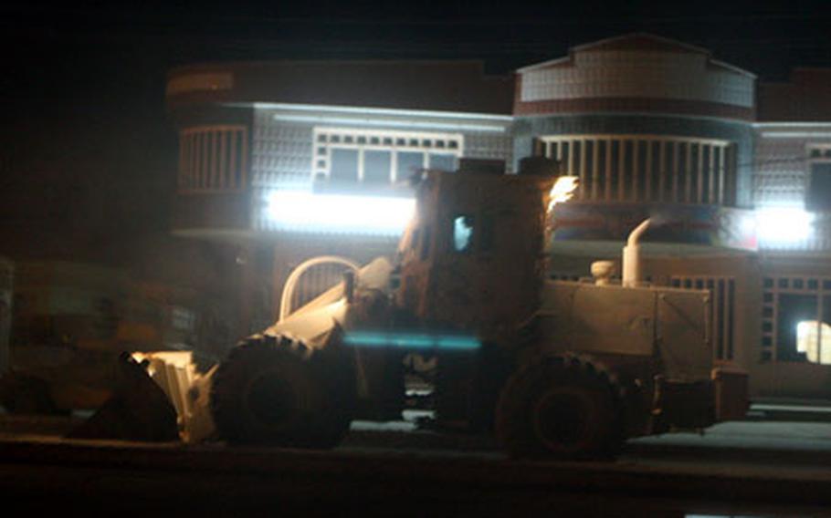 Marines with the Okinawa-based 9th Engineer Support Battalion clean up dirt and trash from the main drag in downtown Fallujah, Iraq. The road was cleared to make it harder for insurgents to plant roadside bombs and carry out other attacks.