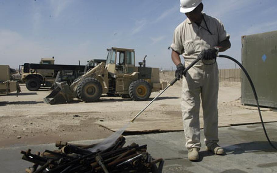 Fred Pagod, 58, of Jacksonville, Fla., an employee with Honeywell Technical Solutions Inc., power-washes tools U.S. Marines use to repair vehicles.