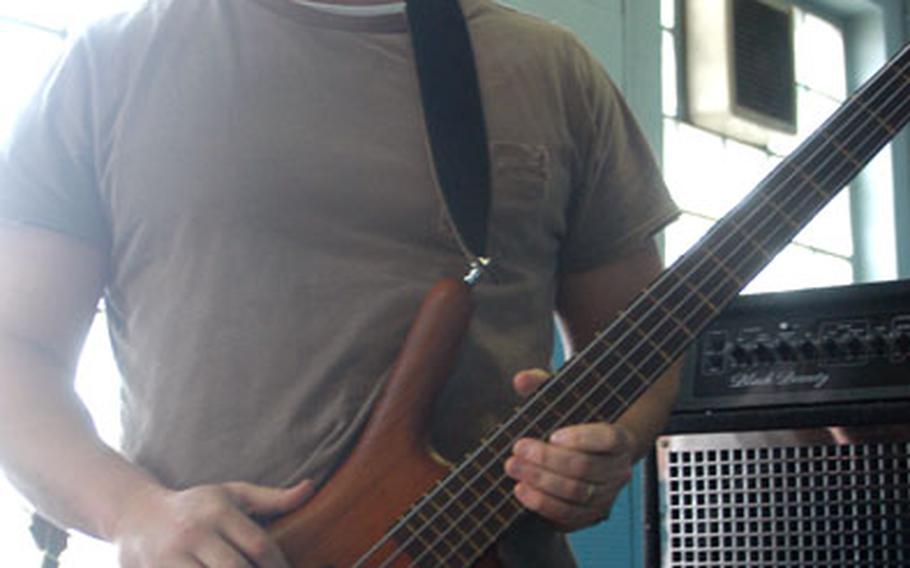 Army Sgt. Jeff Young of the 554th Military Police Company in Stuttgart, Germany, plays bass guitar for the rock band One Brick Shy.
