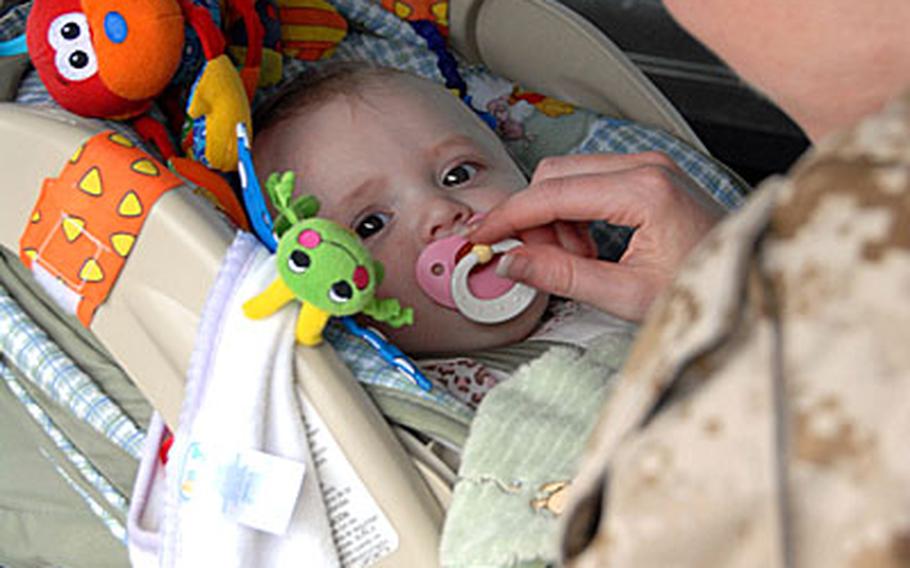 Capt. Sarah Spradlin puts her almost 7-month-old daughter, Alex, into the car Wednesday. Alex's Dad, Capt. Dev. Spradlin, a company commander with 9th Engineer Support Company, deployed a month before she was born.