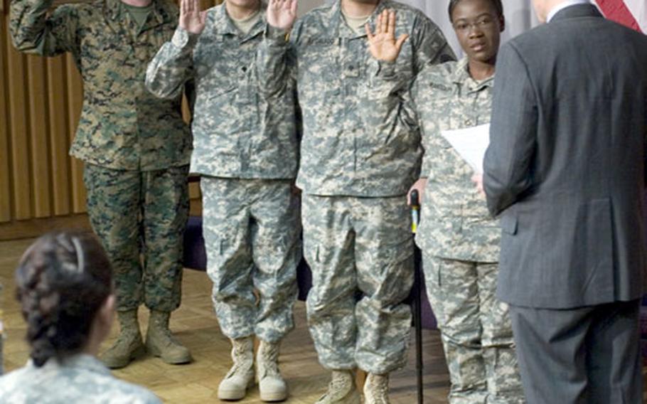 Secretary of Homeland Security Michael Chertoff administers the citizenship oath to, left to right, Lance Cpl. Carlos Lopes, Spc. Eduardo Garcia-Gonzalez, Spc. Angel Regalado-Contreras and Pfc. Dwishnicka Randolph Monday at Walter Reed Army Medical Center in Washington.
