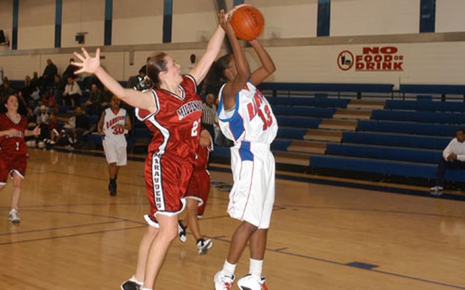 Mildenhall's Bree Waters (left) blocks a shot put up by Ramstein's Cheryl Burney during the USAFE Large Units Basketball Championships held at RAF Lakenheath on Friday. Despite Waters' defensive efforts, the Ramstein Lady Rams cruised past the Lady Marauders 74-38 to capture the women's title. (ukw# 61p rb)