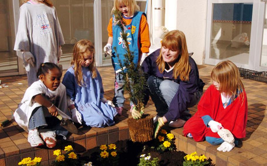 Kelly Sullivan Loughren helps Daisy Troop 37 plant a garden Tuesday at Yokosuka Naval Base. Sullivan is a descendant of the Sullivan brothers who died in World War II.