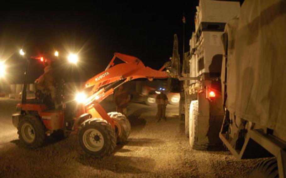 Forklifts unload cargo at Camp Fallujah in the early morning hours Thursday after Marines with 4th Platoon, Transportation Detachment, Supply Company, 2nd Maintenance Battalion and KBRoot employees delivered supplies from Camp Taqaddum, the logistical hub for forces serving in Western Iraq.