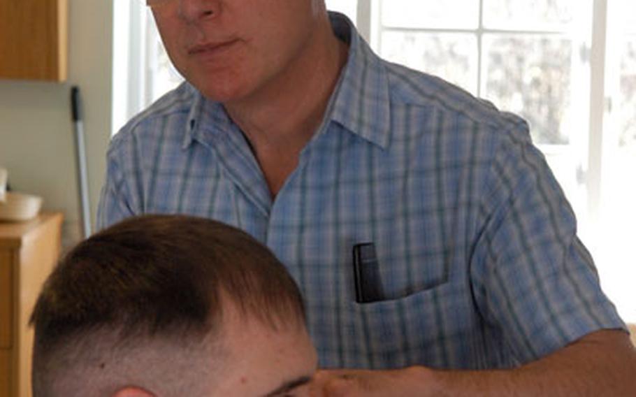Peter Snazell, owner of Cuts R Us, outside RAF Mildenhall, gives Air Force Staff Sgt. Joseph Ogden a haircut.