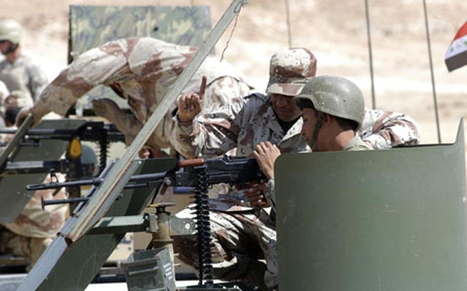 Iraqi infantry school students listen to pointers on loading and shooting from an Iraqi instructor.