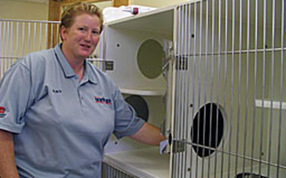 Tracy Perez, animal health care manager for Karing Kennels on Kadena Air Base, displays one of the new cat condos. Karing Kennels' new 8,800 square-foot center is almost four times the size of the old facility.