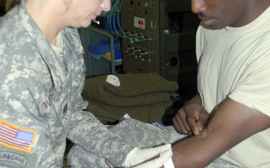 Capt. Kevan Weaver, head nurse of the 212th Combat Support Hospital's emergency medical treatment room, gives intravenous fluids to Sgt. Shawn Sullivan, 28, of Jacksonville, Fla. on Monday.