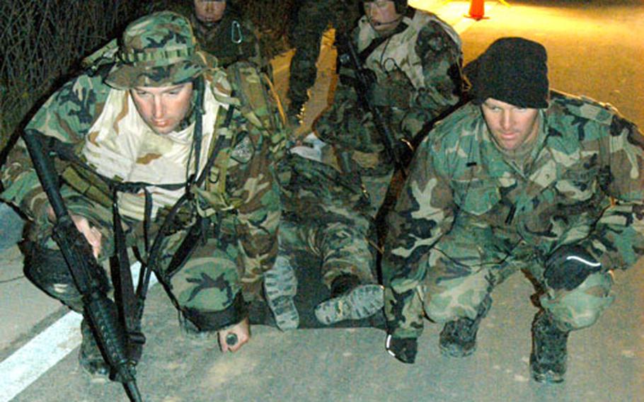 (Clockwise from left front) Coast Guard Petty Officer 1st Class Todd Wimmer, Navy Petty Officer 1st Class John Little, Coast Guard Petty Officer 3rd Class Eric Moss and Navy Petty Office 1st Class Kevin Terney lift simulated casualty Coast Guard Petty Officer 1st Class Tracy Kok during a training exercise Tuesday in Busan.