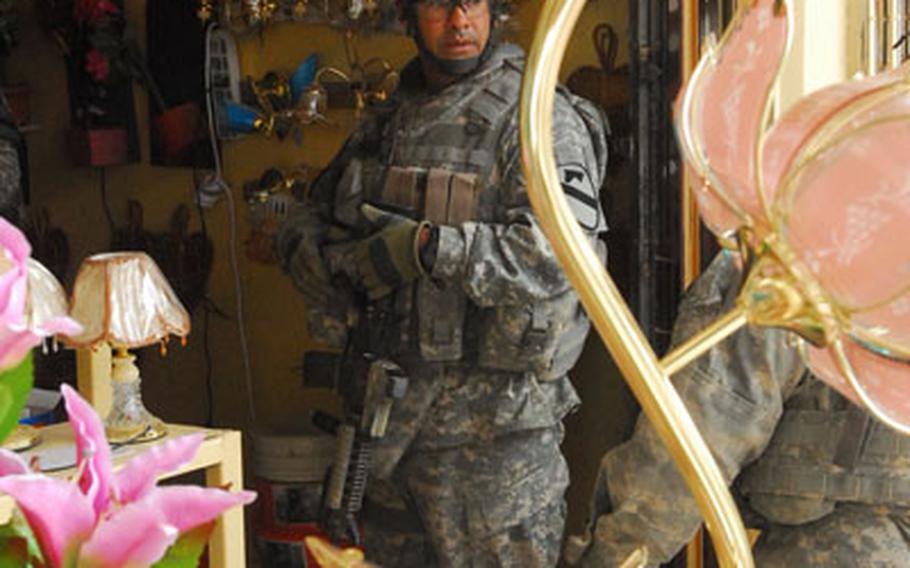 Acting First Sgt. Jose Moran, 39, of San Juan, Puerto Rico, shops for light bulbs and extension cords at an east Baghdad sidewalk store moments before a drive-by shooting Wednesday.