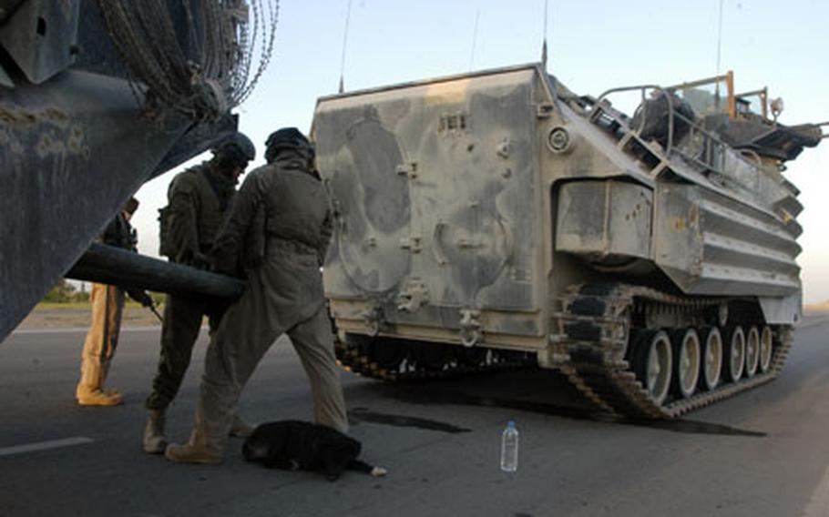 Working as quickly as possible, Marines with 1st Platoon, Company B, Assault Amphibious Battalion, hitch an Assault Amphibious tracked vehicle to another one after a breakdown near the end of a patrol mission Tuesday near Fallujah.