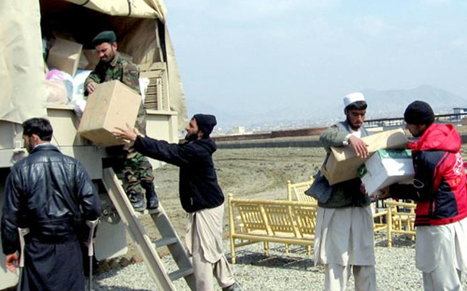 An Afghan National Army soldier helps load a truck with the boxes of donated clothing to distribute to an orphanage in an isolated part of the country about four hours from the base.