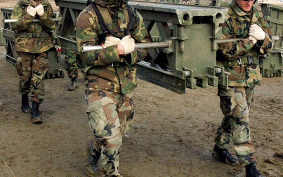 Seabees carry a piece of a girder bridge during an exercise with the South Korean 1175th Bridge Company on Thursday.