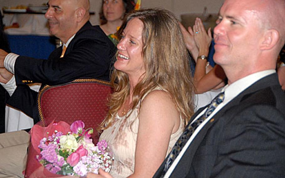 Gina Gray, a key volunteer for the 9th Engineer Support Battalion, listens to the awards presentation after being singled out with a few other volunteers and given flowers for her quick responses to the family readiness officer of 3rd Marine Logistics Group, which held a key volunteer appreciation dinner Friday at the Butler Officers Club.