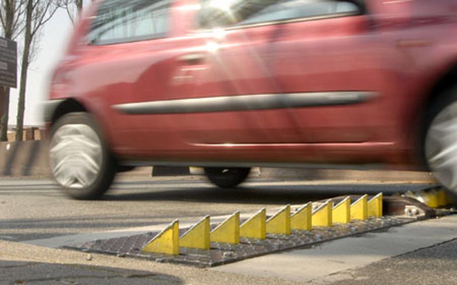 A car travels over tire shredders at Vogelweh’s main gate Monday in Kaiserslautern. At least 10 tires have been damaged by the force-protection device, requiring engineers to make adjustments.