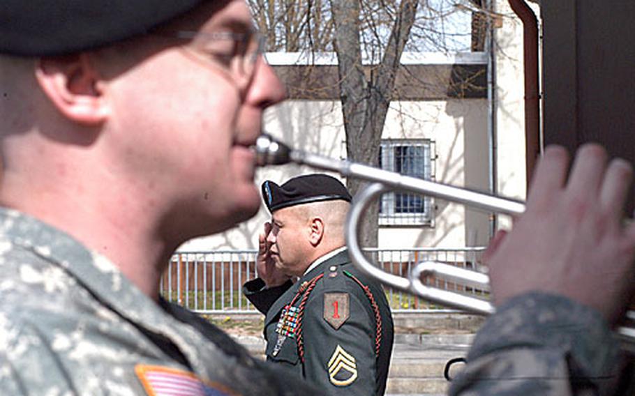 Staff Sgt. Julio Torres, a member of the 299th Forward Support Battalion, 2nd Brigade, 1st Infantry Division, salutes as Spc. George Weber, a member of the 1st Armored Division band, plays taps during a memorial ceremony Thursday for Spc. Sean K. McDonald, a member of the 2nd Brigade's 9th Engineer Battalion, who was killed by a roadside blast Sunday, March 25, in Baghdad.