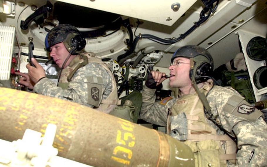 Section chief Sgt. Ralph Dobrovolny, left, and gunner Sgt. Rolando Tucker await orders to fire their Howitzer Paladin at a firing point in Jeongok, north of Dongducheon, on Thursday. The soldiers belong to Fort Sill's 2nd Battalion, 5th Field Artillery, Bravo Battery, which is completing its part of the Reception, Staging, Onward movement and Integration exercise.