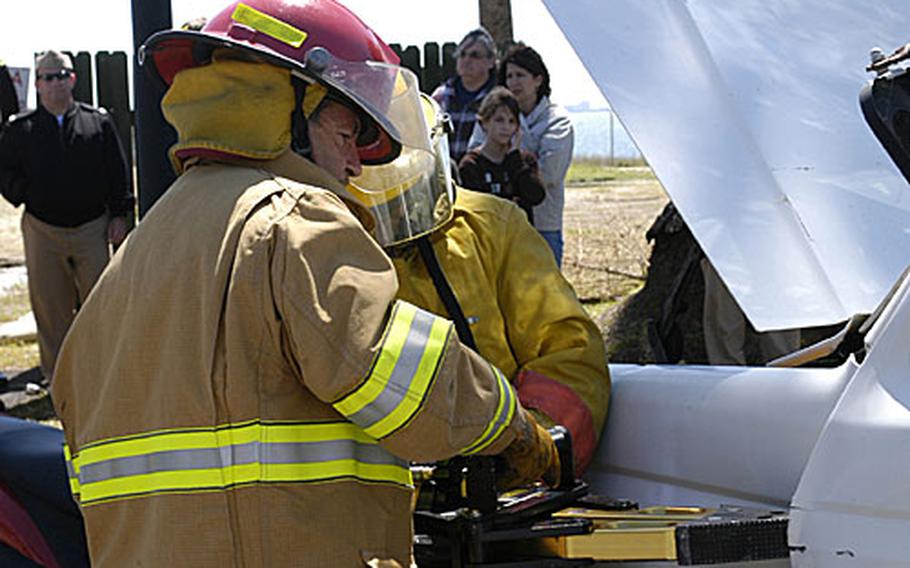 Alfonso Bernal, a Spainish firefighter, right, and Petty Officer 2nd Class Erik Rosen use the "Jaws of Life" to get a simulated crash victim from a vehicle during the "Day of the Dead," a project conceived by Rota high school students to promote awareness of the dangers of drinking and driving.