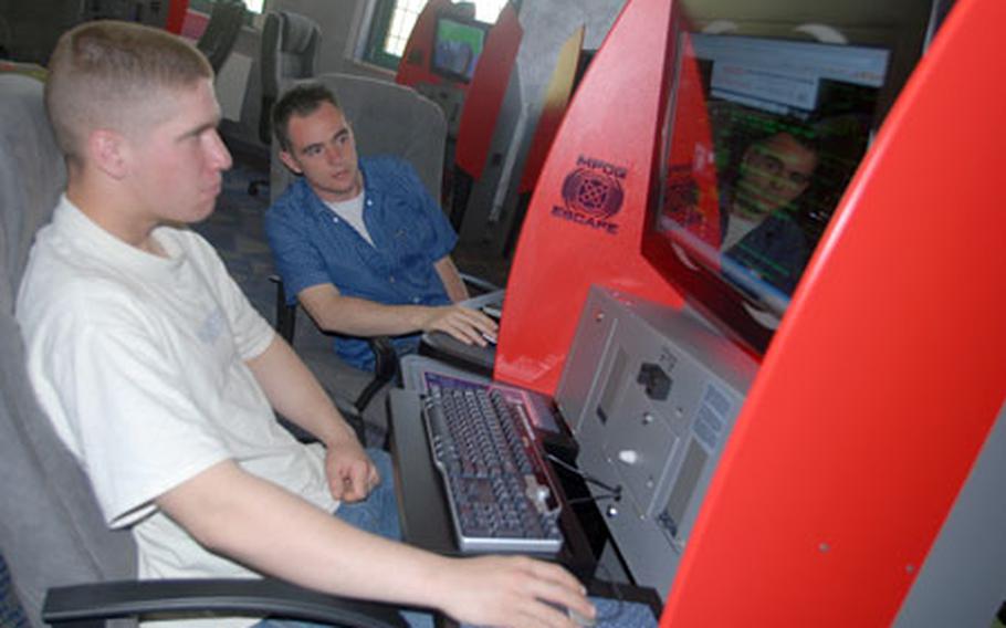 Pfc. Lee Serna, 20, of Corcoran, Cal. (left) and Pfc. Jeff Kempton, 21, of Green Bay, Wis. check out the new multi-player online gaming -- or MPOG -- systems at Vilseck, Germany, on Friday. Twenty MPOG units, designed by the Army, are in Vilseck’s new Java Café coffee shop, which opened at the Langenbruck Center on Friday.