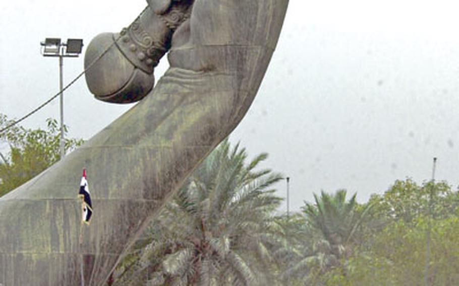U.S. soldiers drive past the so-called “Hands of Victory” monument in downtown Baghdad in December 2004.