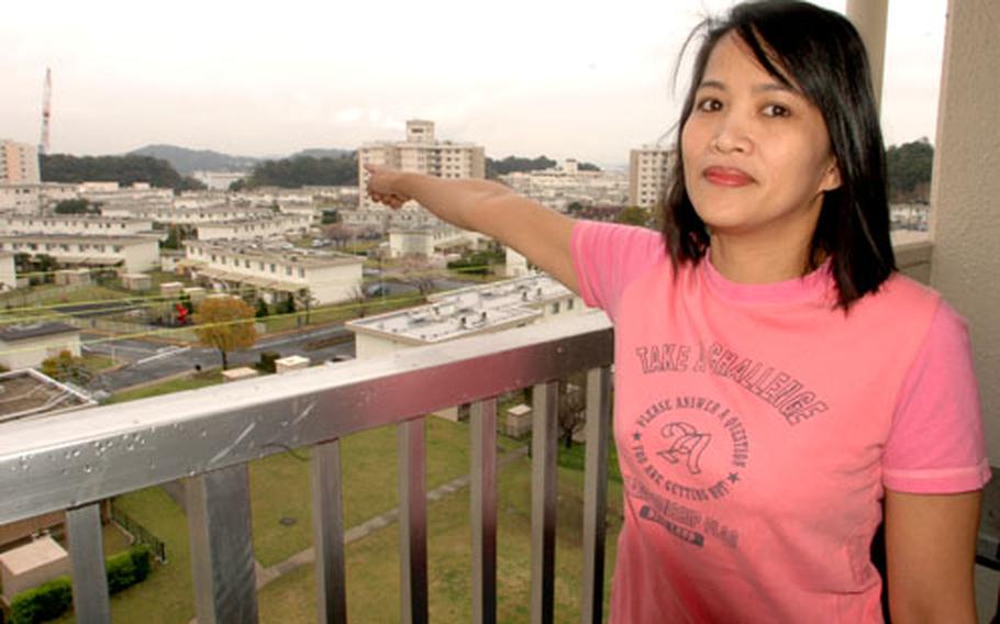 Ellen Angeles, on her Yokosuka Naval Base apartment balcony, points to the Naval Facilities Engineering Command, where she hopes to some day find work as an engineer.