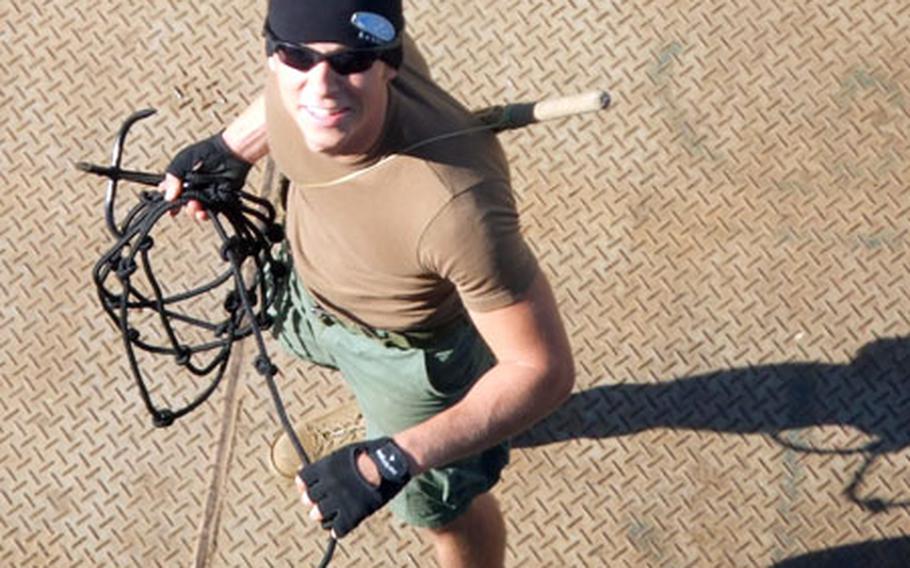 Petty Officer 3rd Class Joshua Fisher, a master-at-arms, prepares to throw a grappling hook as part of training last month for boarding vessels near the Iraqi oil platform Basra in the northern Persian Gulf.