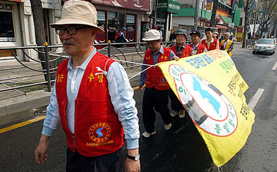 A small group of anti-American protesters march near Yongsan Garrison while a loudspeaker chants “Yankee go home” on Wednesday.