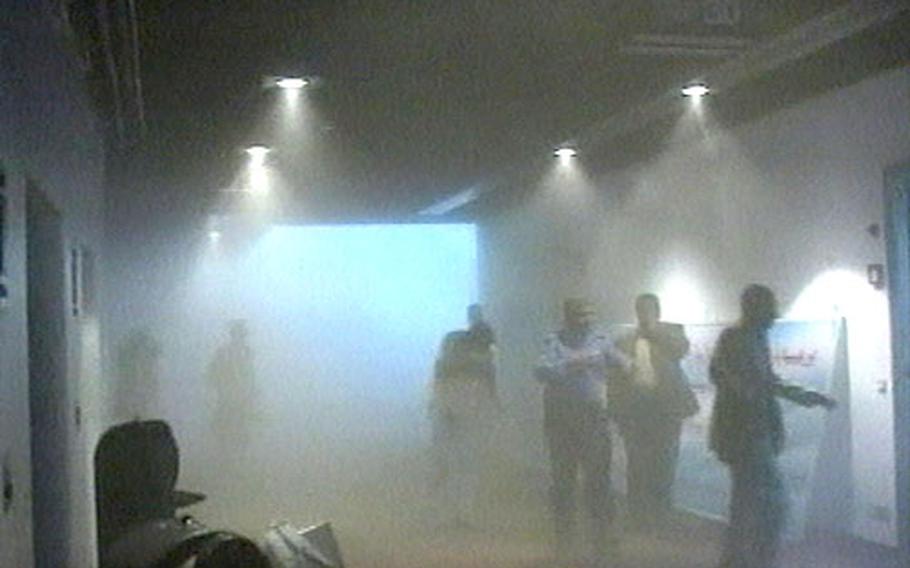 An image from AP Television News shows people leaving the area through thick dust following an explosion in the Iraqi parliament cafeteria within the Green Zone in Baghdad.