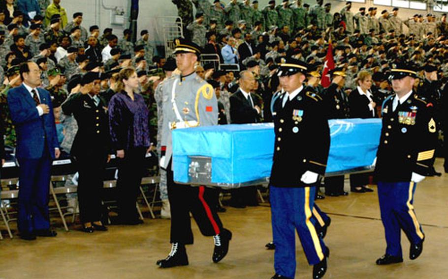 Members of the United Nations Command Honor Guard carry the remains of UNC service members who died in the Korean War to hearses after a repatriation ceremony at Yongsan Garrison’s Collier Field House, Thursday.