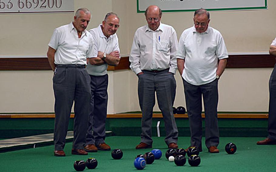 Members of the Ely Bowls Club watch a wood approach the "head" at a recent league match.