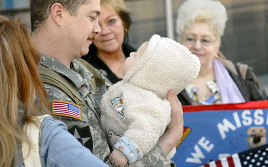 Tech. Sgt. Adam Jensen, a joint terminal attack controller assigned to the 1st Air Support Operations Squadron at Ramstein Air Base, Germany, gazes into the eyes of his 7-month-old son, Cayden, after returning home Saturday from a six-month deployment to Baghdad, Iraq. Jensen is surrounded by his wife, Aljona, foreground, his mother Darlene, center, and his mother-in-law Katerina, right.