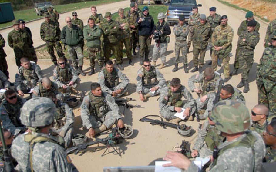 NATO personnel listen in as U.S.soldiers from the 1st Battalion, 4th Infantry Regiment are given instructions during a counter-roadside bomb exercise conducted for the visiting NATO troops at Hohenfels' Joint Multinational Readiness Center on Friday.
