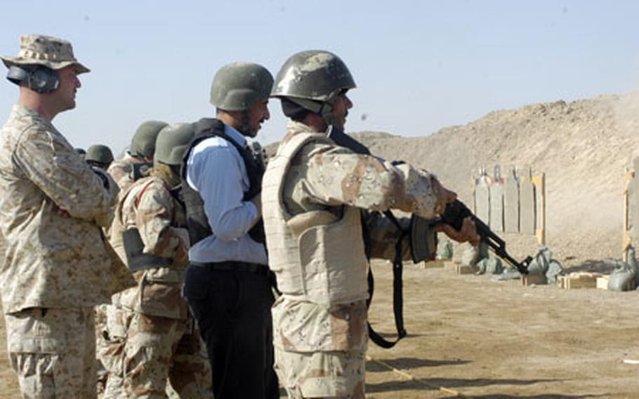 Iraqi police officers, in blue uniforms, receive marksmanship training along with Iraqi soldiers at a U.S. Marine Corps-led Iraqi Small Arms Instructor Training Course in Camp Habbaniyah. Iraqi police often are on the front line fighting insurgents, and being pistol proficient alone isn’t enough, so they also get training on AK-47s.