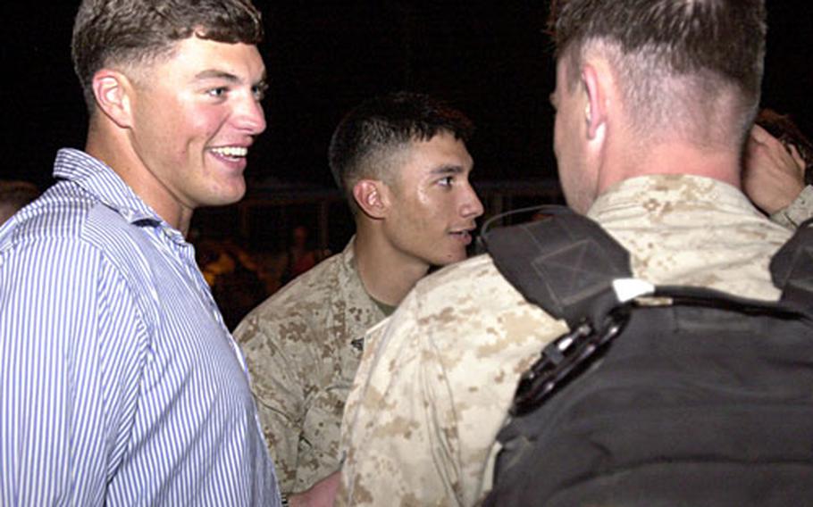 Sgt. Sam Meek, left, greets buddies that he has not seen since he was wounded in Iraq in January and sent to a burn center in Texas. He and two other 3rd Recon Marines, wounded and returned to the States during the unit’s deployment to Iraq, flew to Okinawa to be part of Tuesday’s welcome-home reception at Camp Schwab.