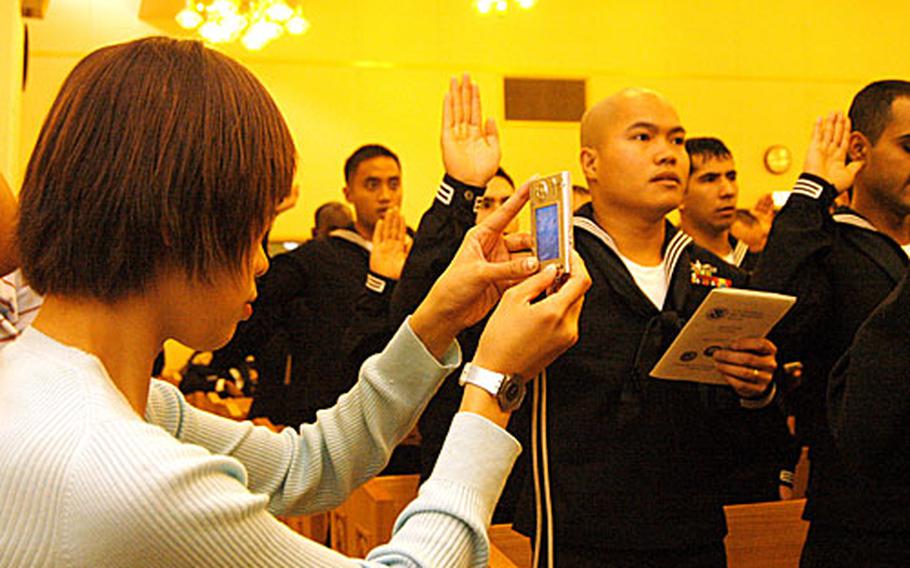 More and more non-citizen military members are taking advantage of the expedited, no cost naturalization process, according to U.S. Citizenship and Immigration Services. Friday's ceremony -- with 121 servicemembers from 34 countries -- was the biggest ceremony held to date at Yokosuka Naval Base.