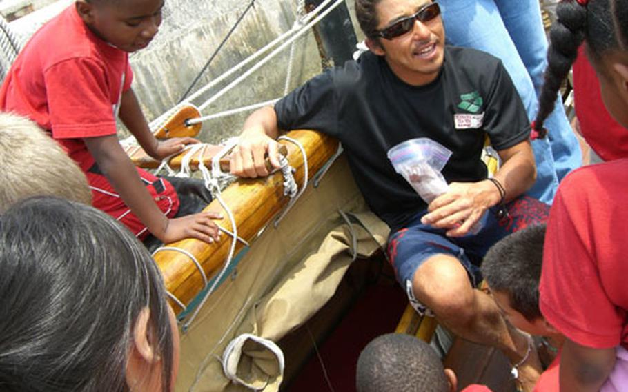 Helping the students get hands-on experience of sailing with the canoe is crewmember Takuji Araki. Araki shows them a ‘bedroom’ for the crew, a narrow bunk in the canoe’s bottom.