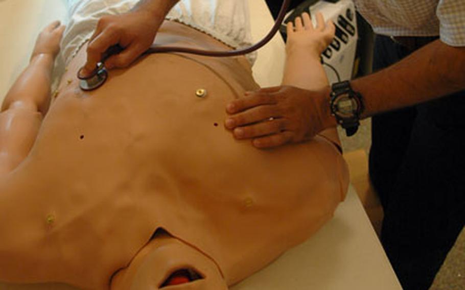 An Iraqi doctor listens for simulated signs of life in a computerized first-aid mannequin recently during a training session at Ibn Sina Hospital in Baghdad's Green Zone. The physician, who also works as a translator, agreed to be photographed but asked not to have his real name not be printed for security reasons.