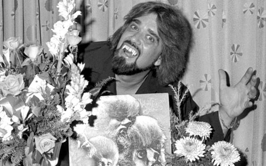 Wearing fake fangs for added effect, disc jockey Wolfman Jack strikes a menacing pose during an interview in Tokyo in 1976.