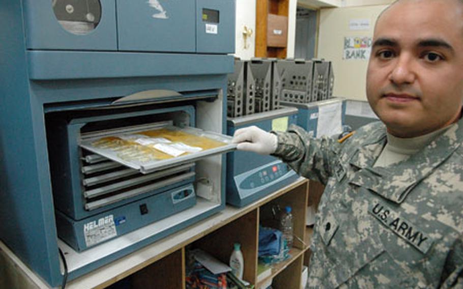 Spec. Carlos Martinez, 26, of Myrtle Beach, S.C., examines a tray of blood platelets in a blood agitator Friday. The machine rocks the blood clotting agents back and forth so that they can be stored without clotting.