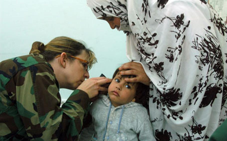 Dr. (Maj.) Angela Wall examines the ear of a young patient during a humanitarian medical mission in Fask, Morocco, on April 22. The little girl was diagnosed with an infection and given antibiotics.