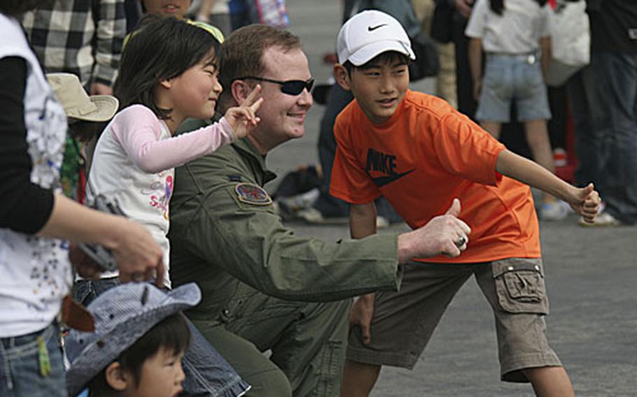 A U.S. Marine pilot and two young Japanese children pose for a photo during Saturday&#39;s 35th annual Friendship Day.