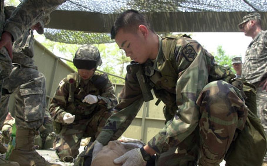 Sgt. Rizmel Paguio of the 16th Medical Logistics Battalion checks for head injuries after inserting a chest catheter earlier on a mannequin at Warrior Base Monday. Paguio is among 284 soldiers who will compete for the Expert Field Medical Badge later this week.