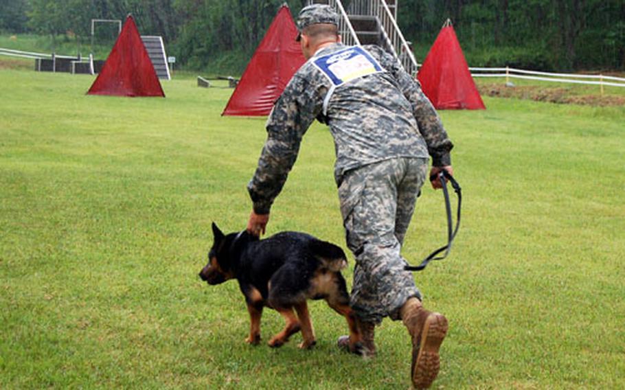 Sgt. Christopher Jasper sends his German Shepherd, Argo, after a simulated suspect during the controlled aggression portion of the 4th Annual U.S. Forces Korea Military Working Dog Competition.