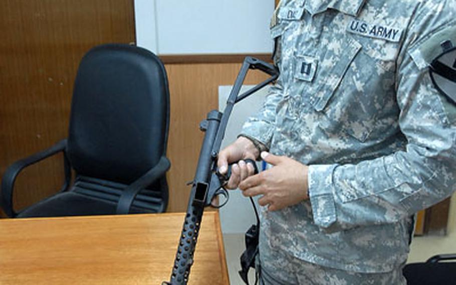 Capt. Rene Diaz holds a World War II-era Sterling submachine gun. The vintage weapon is one of several valuable weapons Diaz's unit, the 2nd Battalion of the 5th Cavalry in Abu Ghraib, find among the hidden caches of insurgents.