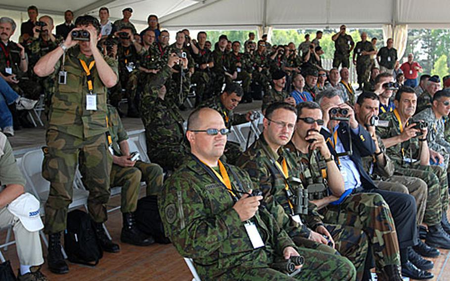 Delegates from the Organization for Security and Cooperation in Europe watch U.S. Army Stryker armored personnel carriers perform at Grafenwöhr Training Area.