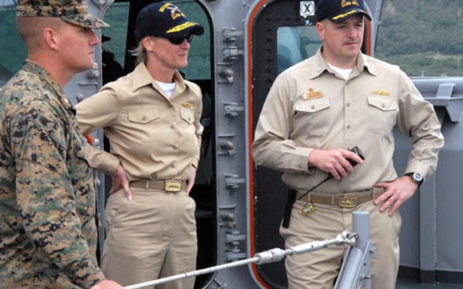 Pottenger stands with Cmdr. David Bossert, right, captain of USS Harpers Ferry, and Lt. Col. Tracey King, left, as the ship pulls into port at White Beach Naval Facility, Okinawa, in early 2007.