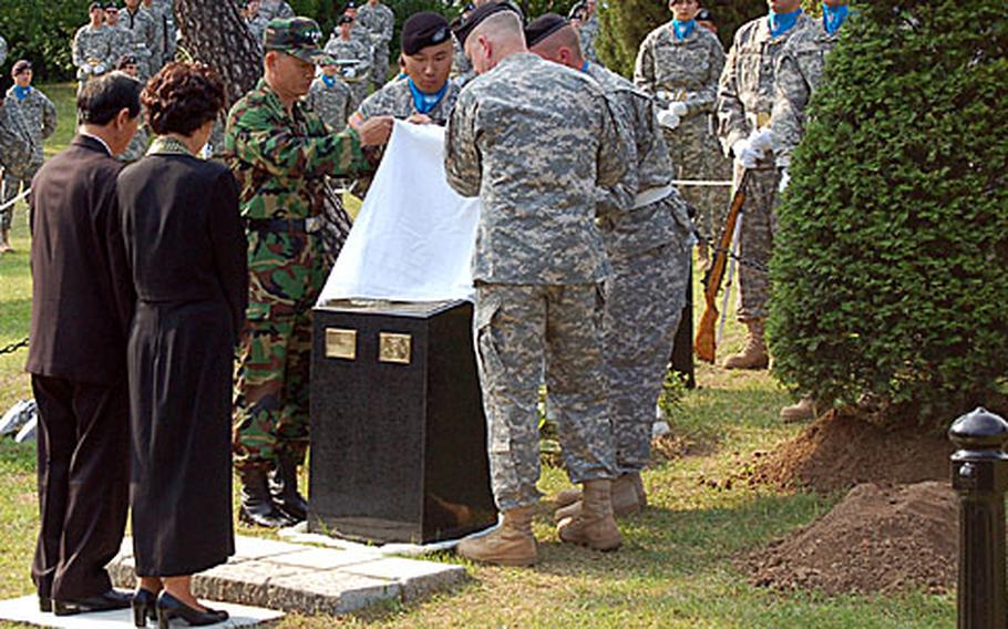 Combined Forces Command commander, Gen. B.B. Bell, deputy commander Gen. Kim, Byung-kwan and members of the United Nations Command Honor Guard unveil a marker dedicated to slain South Korean soldier, Staff Sgt. Yoon, Jang-ho, while his parents Lee, Chang-hee and Yoon, Hee-chul look on.